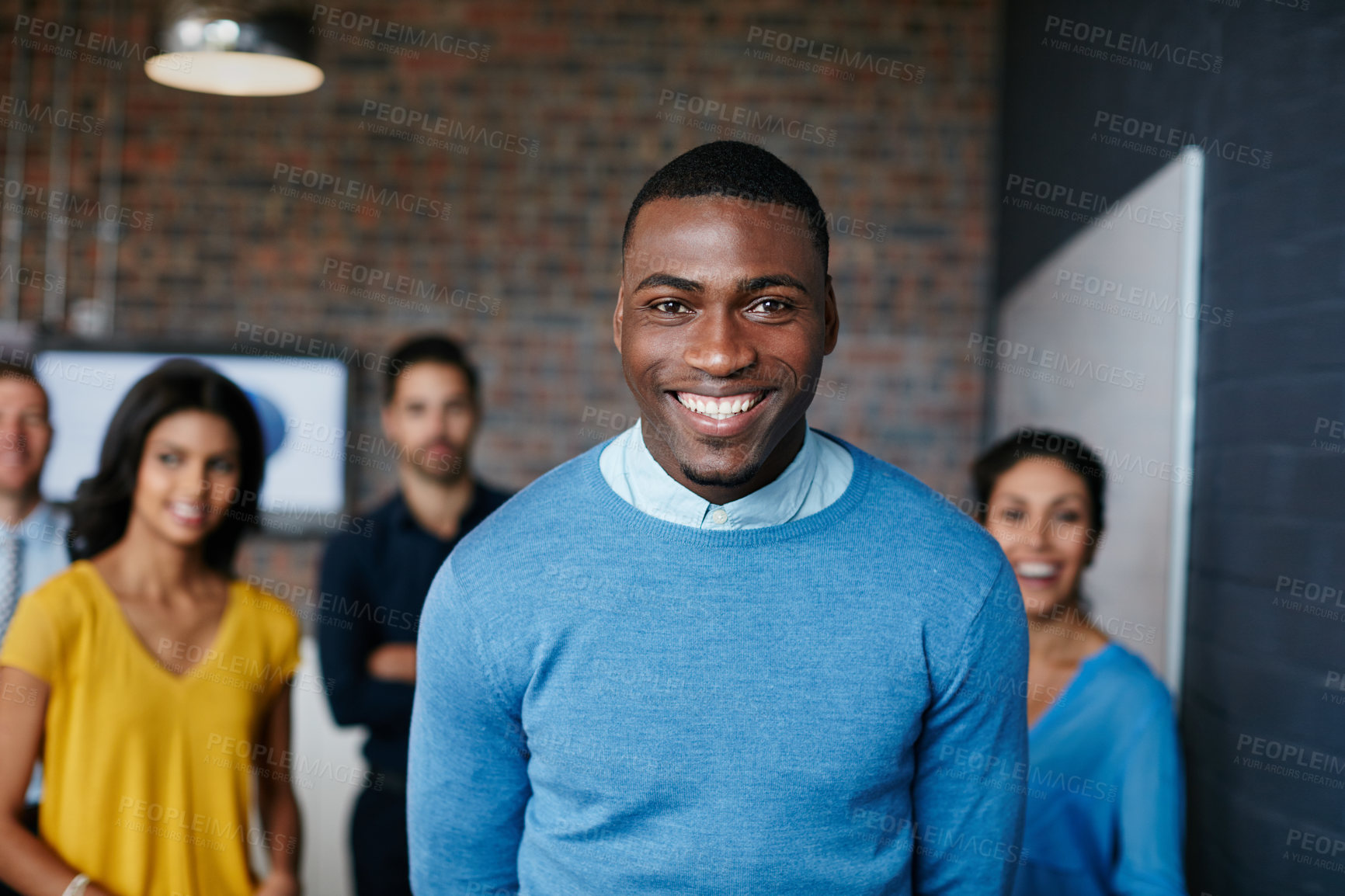 Buy stock photo Cropped portrait of a businessman standing in the workplace with his colleagues in the background