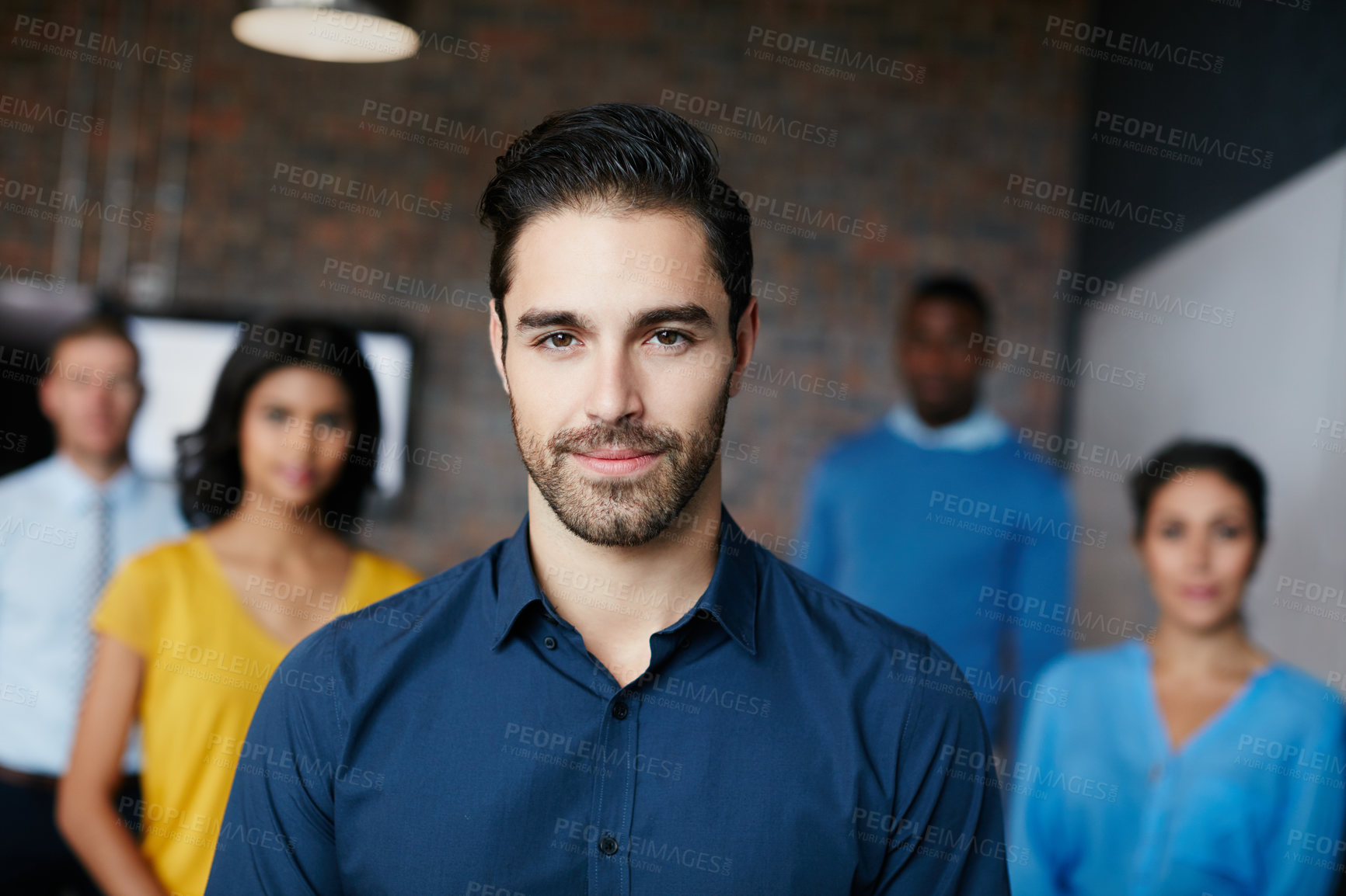 Buy stock photo Cropped portrait of a businessman standing in the workplace with his colleagues in the background