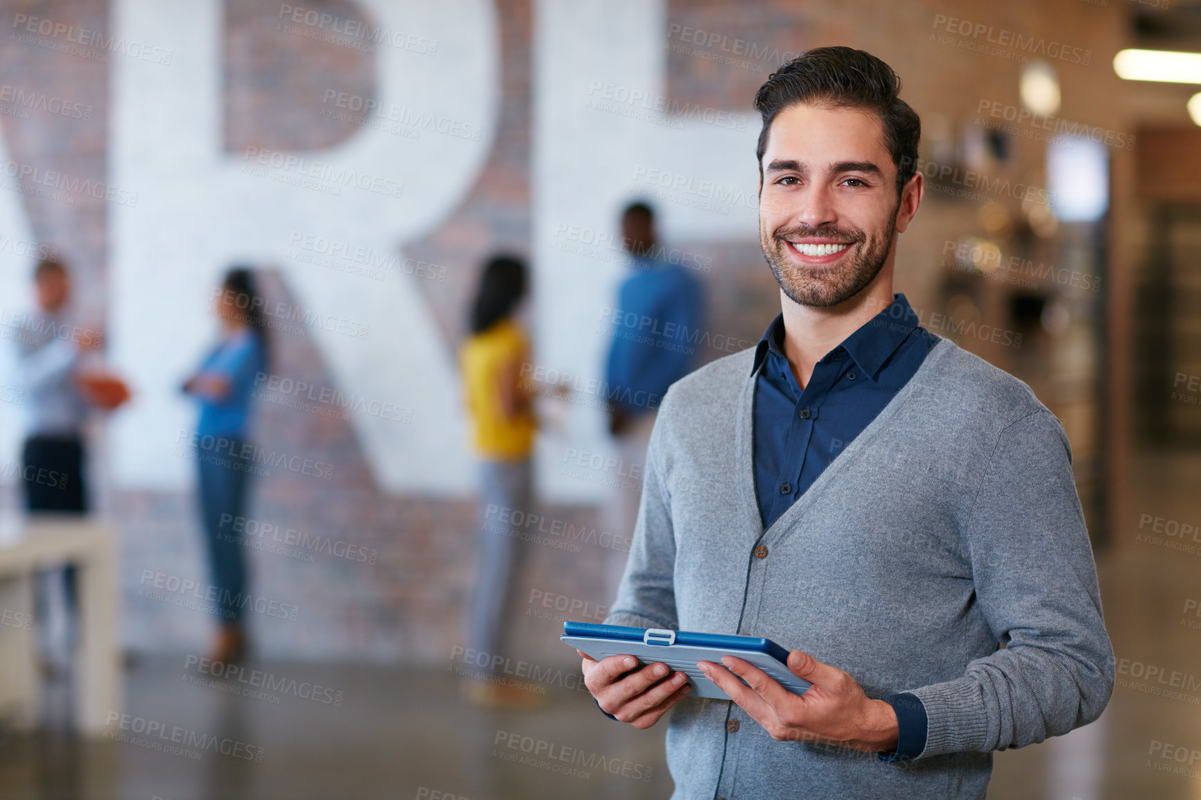 Buy stock photo Cropped portrait of a young man standing with a tablet in the office