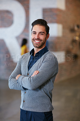 Buy stock photo Cropped portrait of a young man standing with his arms folded in the office