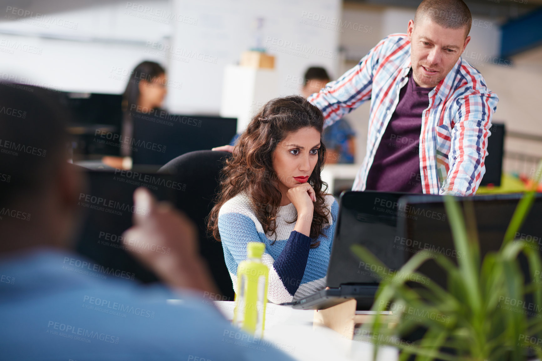 Buy stock photo Shot of two coworkers using a computer together in a modern office