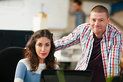 Buy stock photo Shot of two coworkers using a computer together in a modern office
