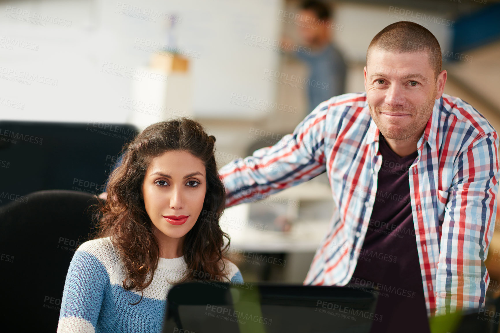 Buy stock photo Shot of two coworkers using a computer together in a modern office