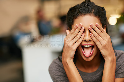 Buy stock photo Shot of a playful young woman covering her eye in a modern office