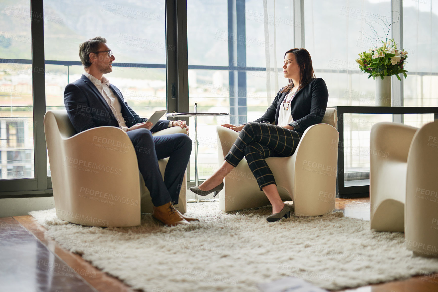 Buy stock photo Shot of two businesspeople talking in a corporate office