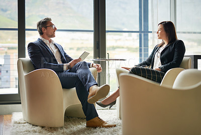 Buy stock photo Shot of two businesspeople talking in a corporate office