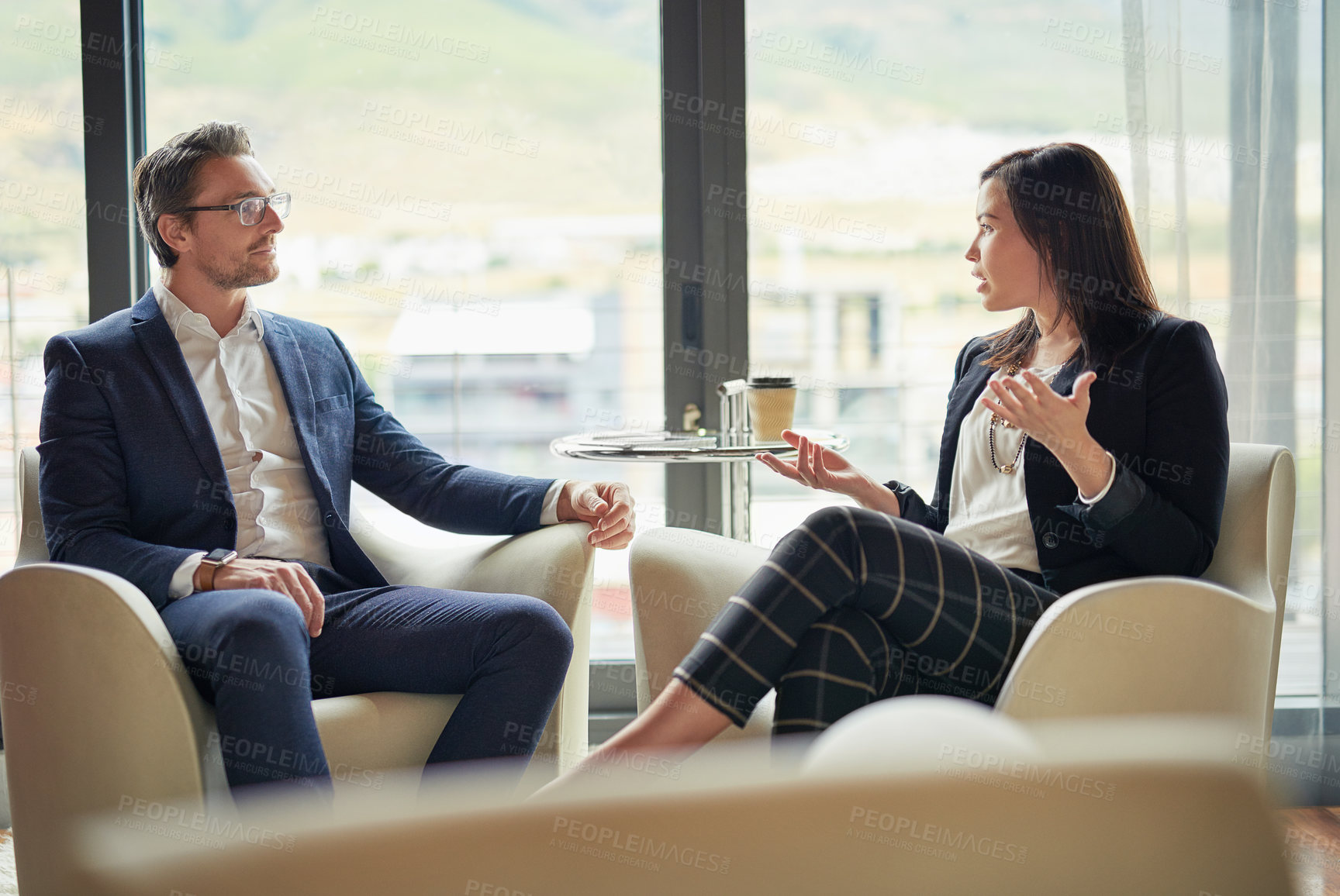 Buy stock photo Shot of two businesspeople talking in a corporate office