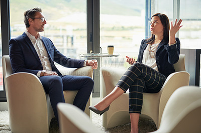 Buy stock photo Shot of two businesspeople talking in a corporate office