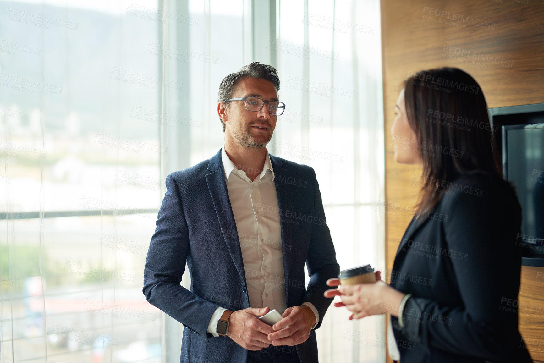Buy stock photo Shot of two businesspeople talking in a corporate office