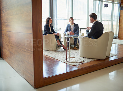 Buy stock photo Shot of three businesspeople talking in a corporate office