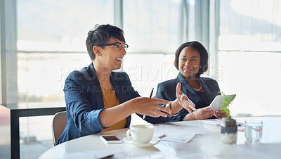 Buy stock photo Shot of two corporate businesswomen sitting in the boardroom