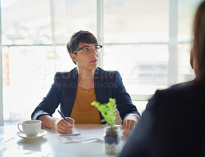 Buy stock photo Shot of two corporate businesspeople sitting in the boardroom