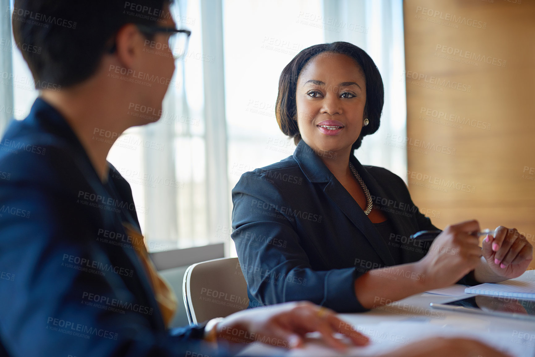 Buy stock photo Shot of two corporate businesswomen working in the boardroom