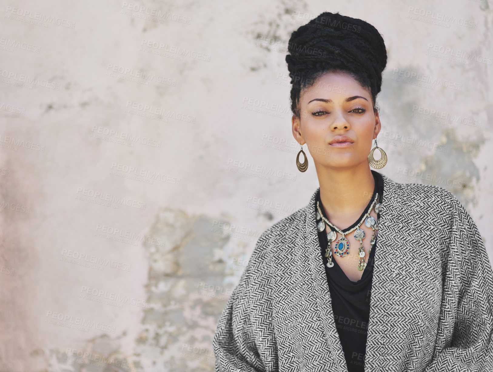 Buy stock photo Portrait of a fashionable young woman posing against a wall