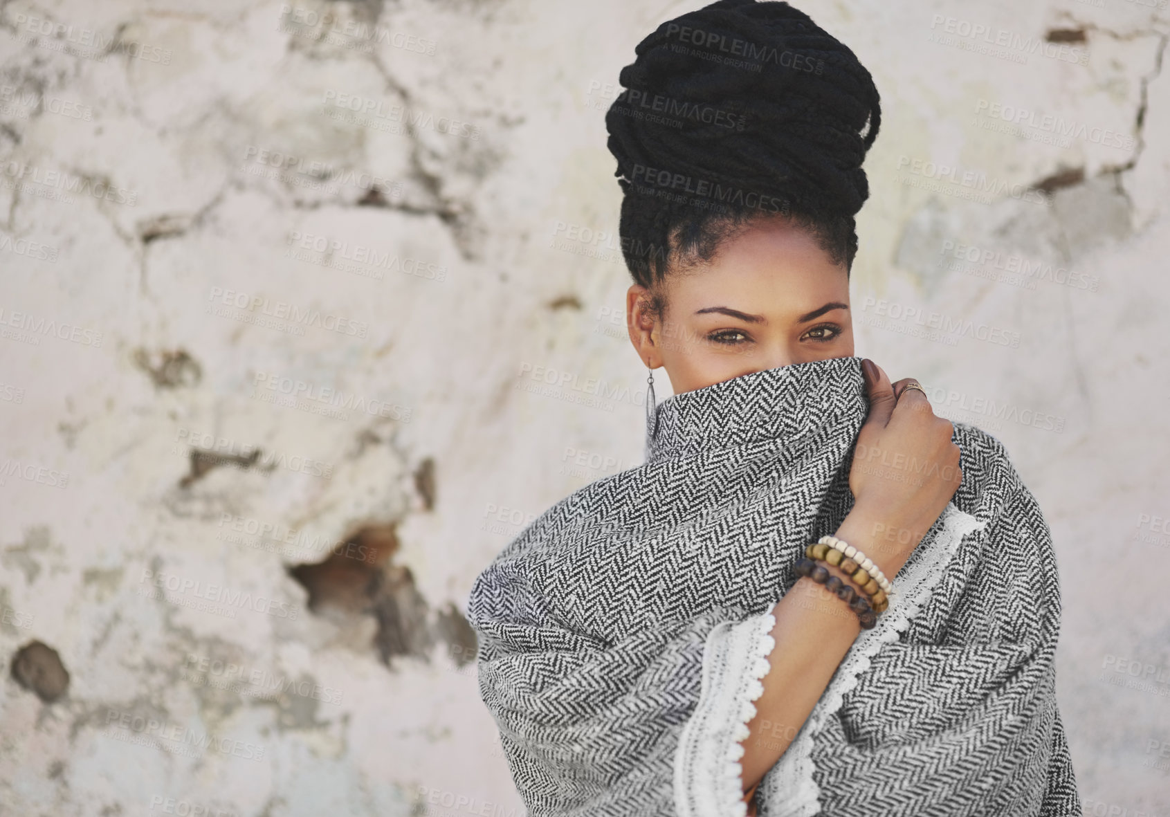 Buy stock photo Cropped portrait of an attractive young woman covering her mouth with her poncho