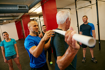 Buy stock photo Shot of a senior man doing pvc pipe exercises with the assistance of his trainer