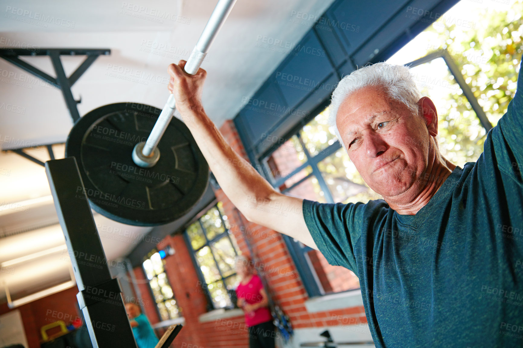 Buy stock photo Shot of a senior man doing weight training at the gym