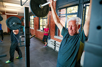 Buy stock photo Shot of a senior man doing weight training at the gym