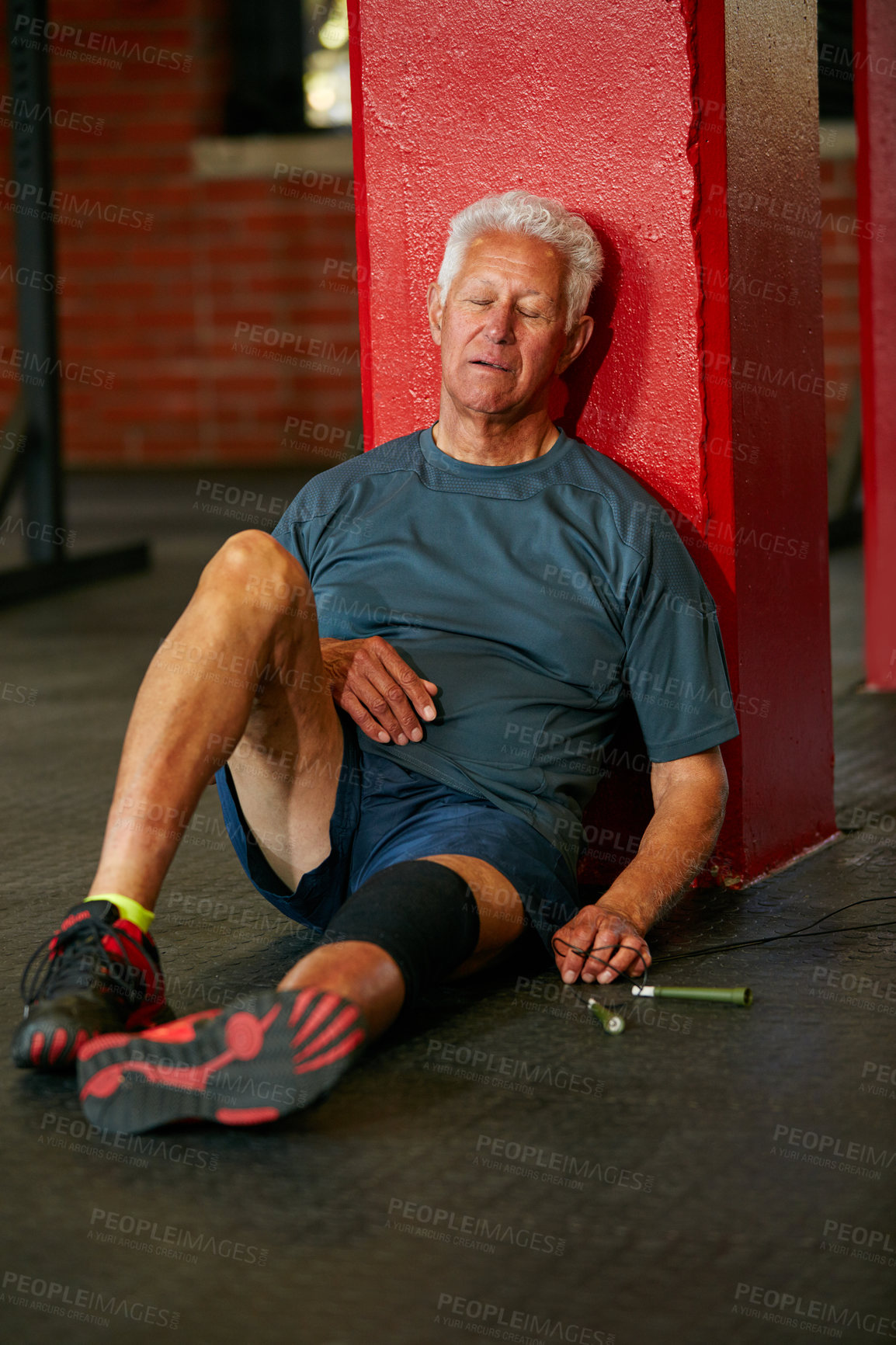 Buy stock photo Shot of a senior man taking a break from an exhausting workout