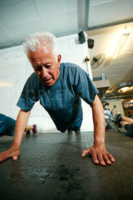 Buy stock photo Shot of a senior man working out in the gym