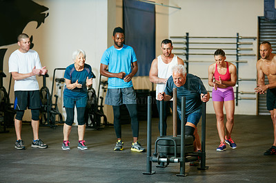 Buy stock photo Full length shot of a group of people cheering on a senior man in the gym