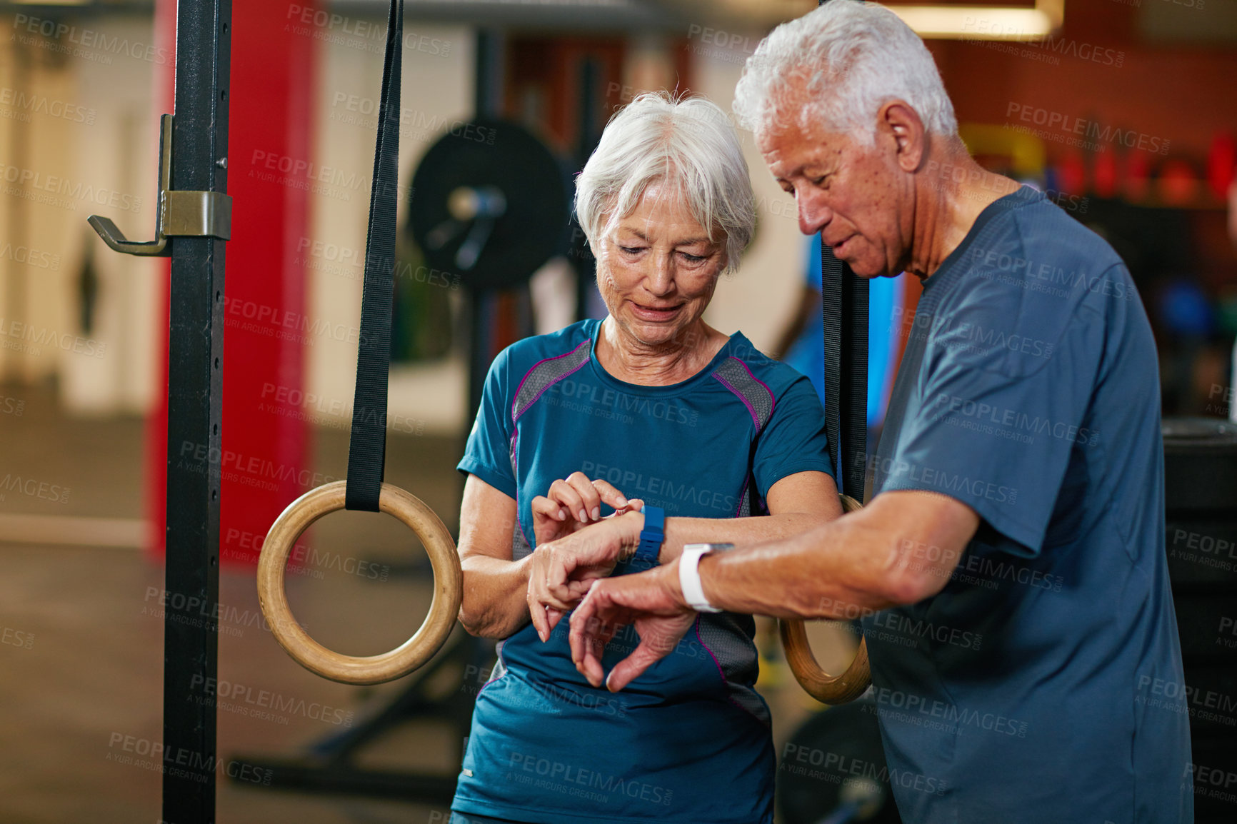 Buy stock photo Senior couple, smart watch and talk at gym with results, review and smile for progress at exercise studio. Old man, woman and check with iot clock, monitor or fitness app with stats in retirement