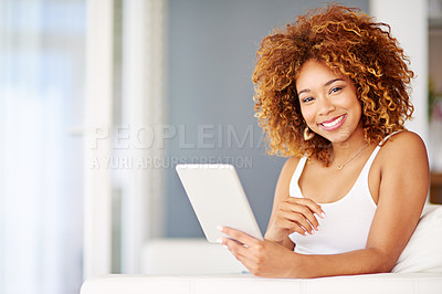 Buy stock photo Portrait of a young woman using a digital tablet on the sofa at home