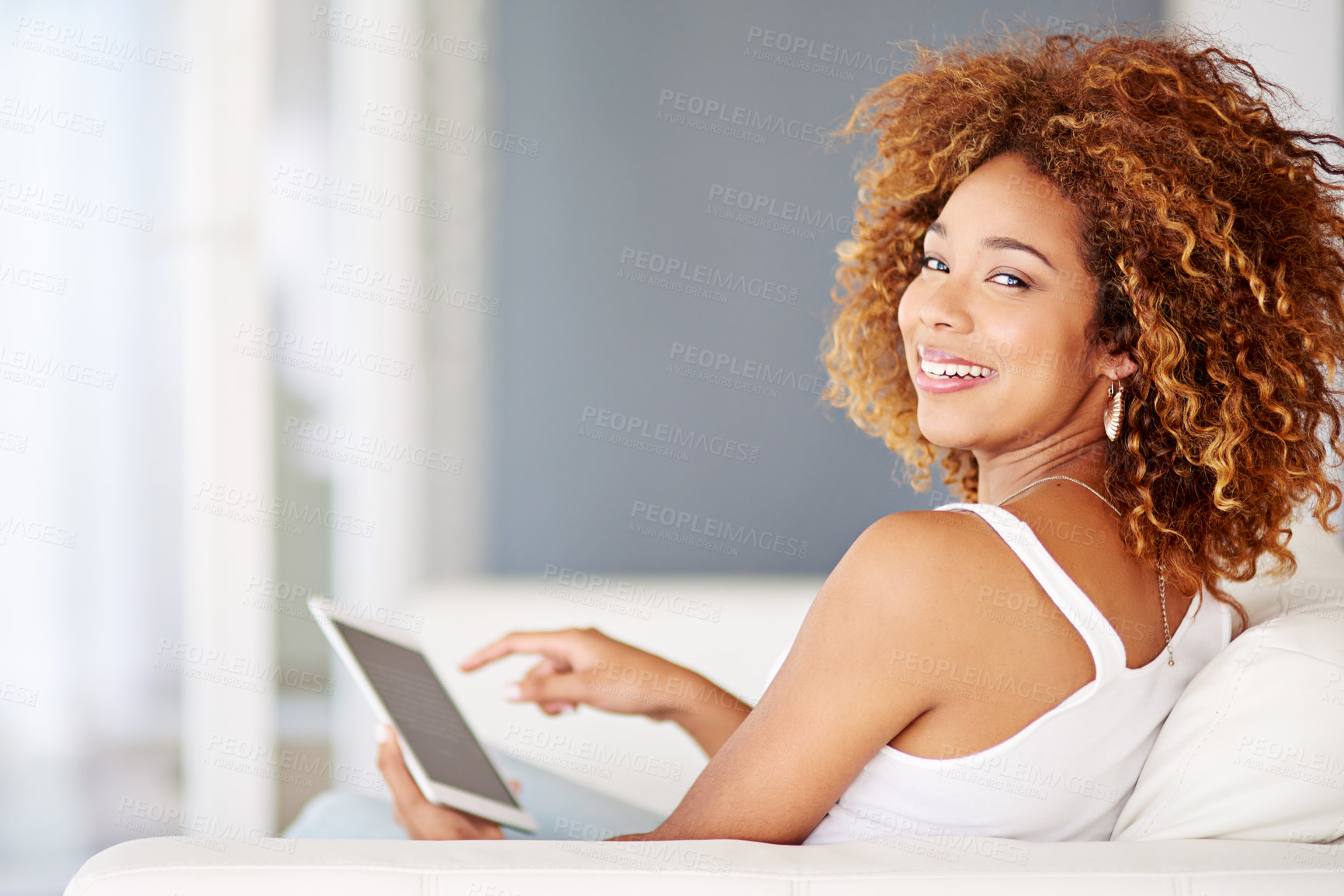 Buy stock photo Portrait of a young woman using a digital tablet on the sofa at home