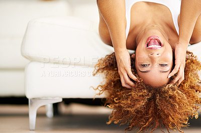 Buy stock photo Shot of a young woman lying upside down on her couch