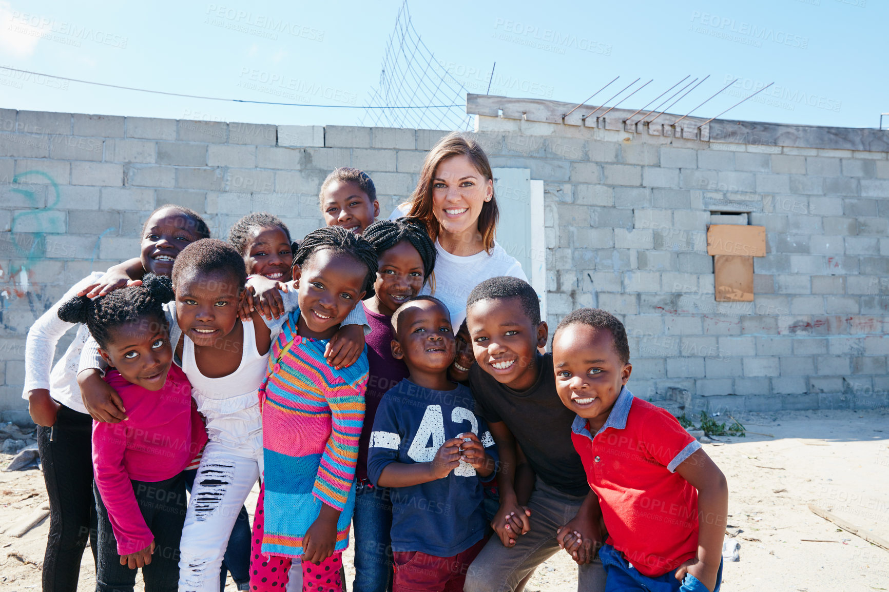 Buy stock photo Portrait of a volunteer worker with a group of kids at a community outreach event