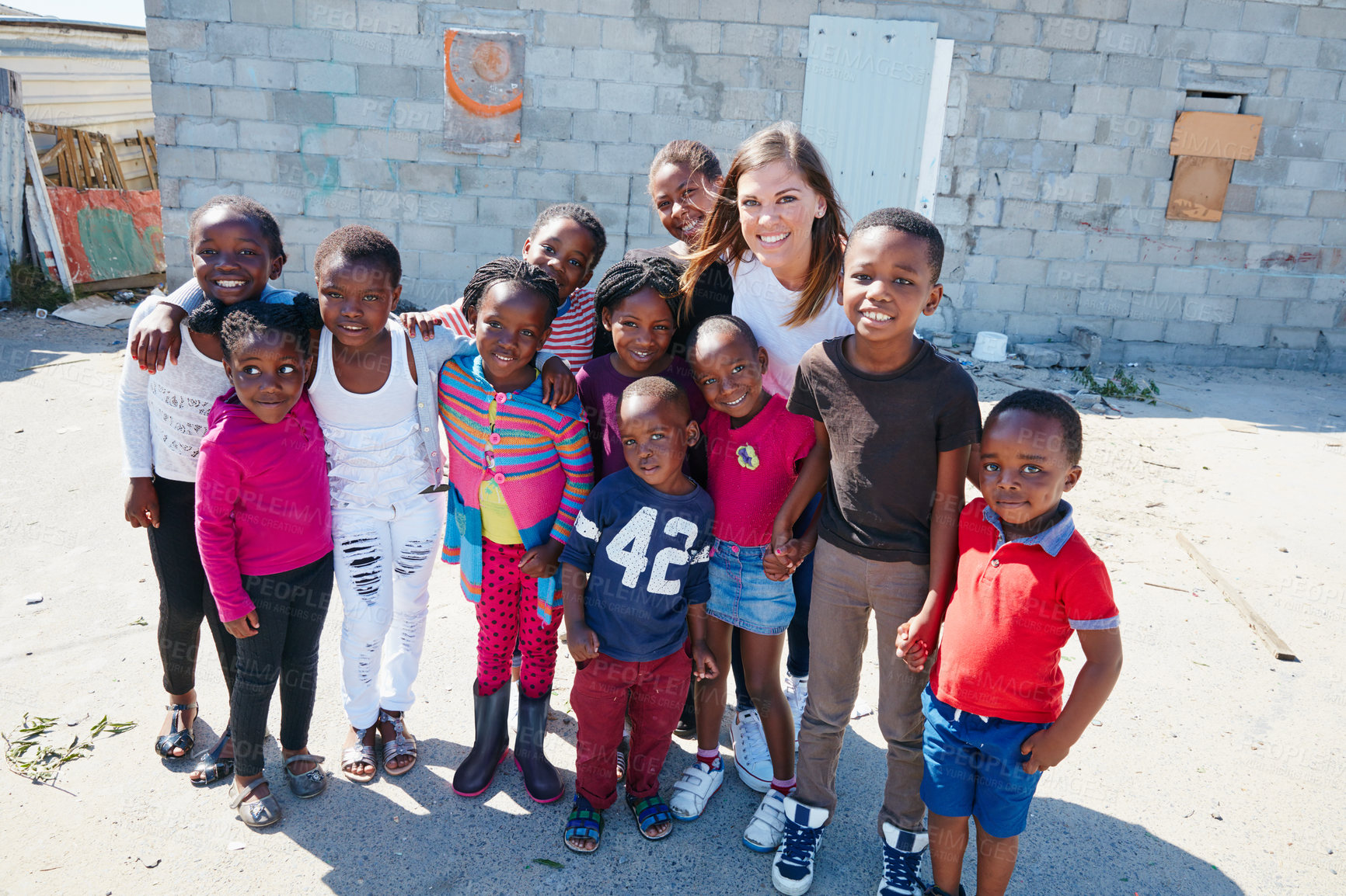 Buy stock photo Portrait of two volunteer workers addressing a group of kids at a community outreach event