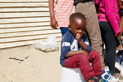 Buy stock photo Cropped shot of a young boy sitting with a group of other children at a community outreach event