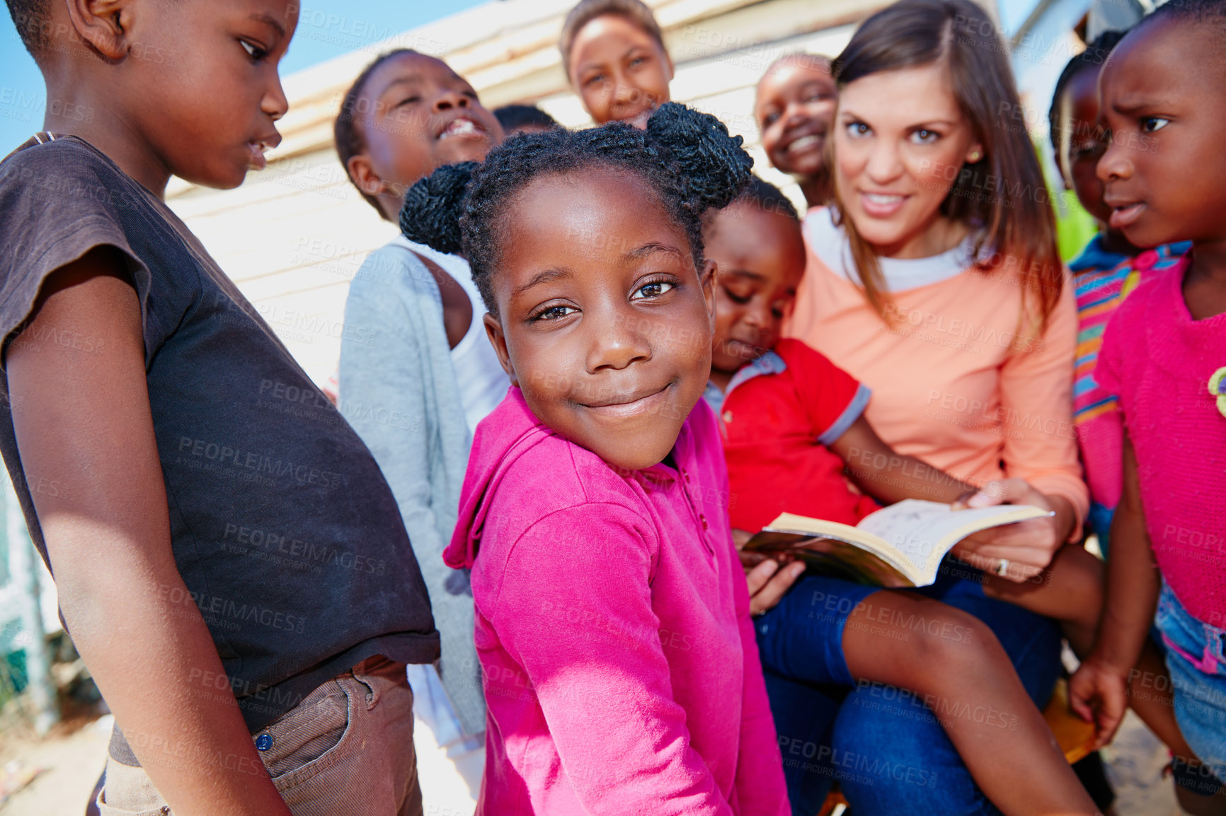 Buy stock photo Reading, charity and portrait of children outdoor for ngo organization, education drive and support. Learning foundation, social responsibility and book with woman and kids for welfare volunteer