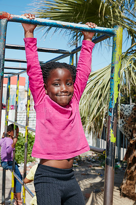 Buy stock photo Portrait of a happy little girl hanging on a jungle gym
