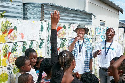 Buy stock photo Cropped shot of volunteer workers addressing a group of children at a community outreach event