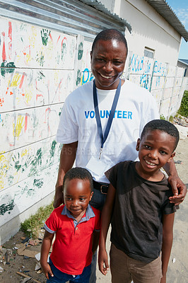 Buy stock photo Cropped portrait of a volunteer worker and two young boys at a community outreach event
