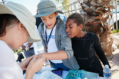 Buy stock photo Cropped shot of volunteer nurses giving checkups to underprivileged kids