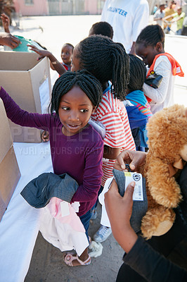 Buy stock photo Cropped shot of underprivileged kids receiving clothing
