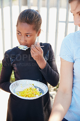 Buy stock photo Cropped shot of a young girl getting fed at a food outreach
