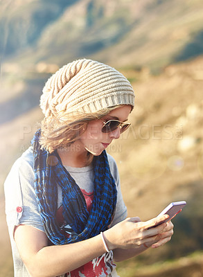 Buy stock photo Cropped shot of a teenage girl sending a text message outdoors