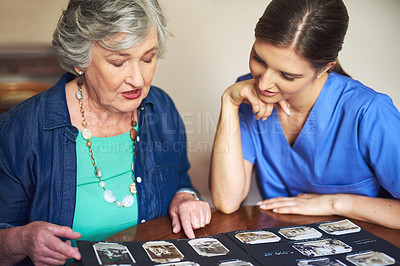 Buy stock photo Shot of a resident and a nurse looking through a photo album