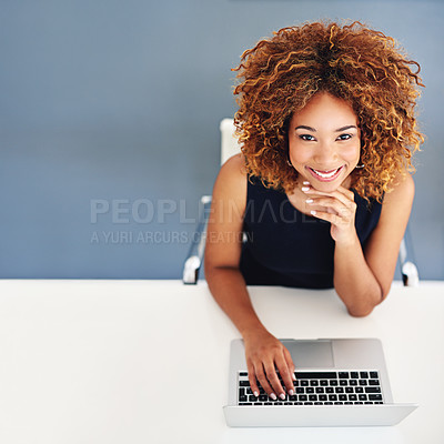 Buy stock photo Portrait of a young businesswoman working on a laptop at her desk