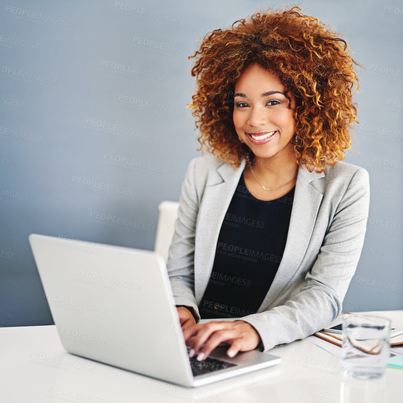 Buy stock photo Portrait of a young businesswoman working on a laptop at her desk