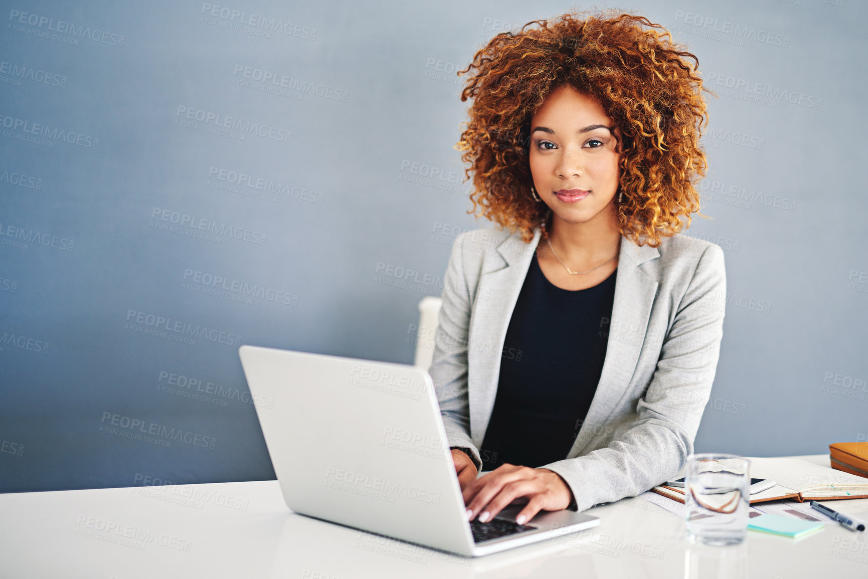 Buy stock photo Portrait of a young businesswoman working on a laptop at her desk