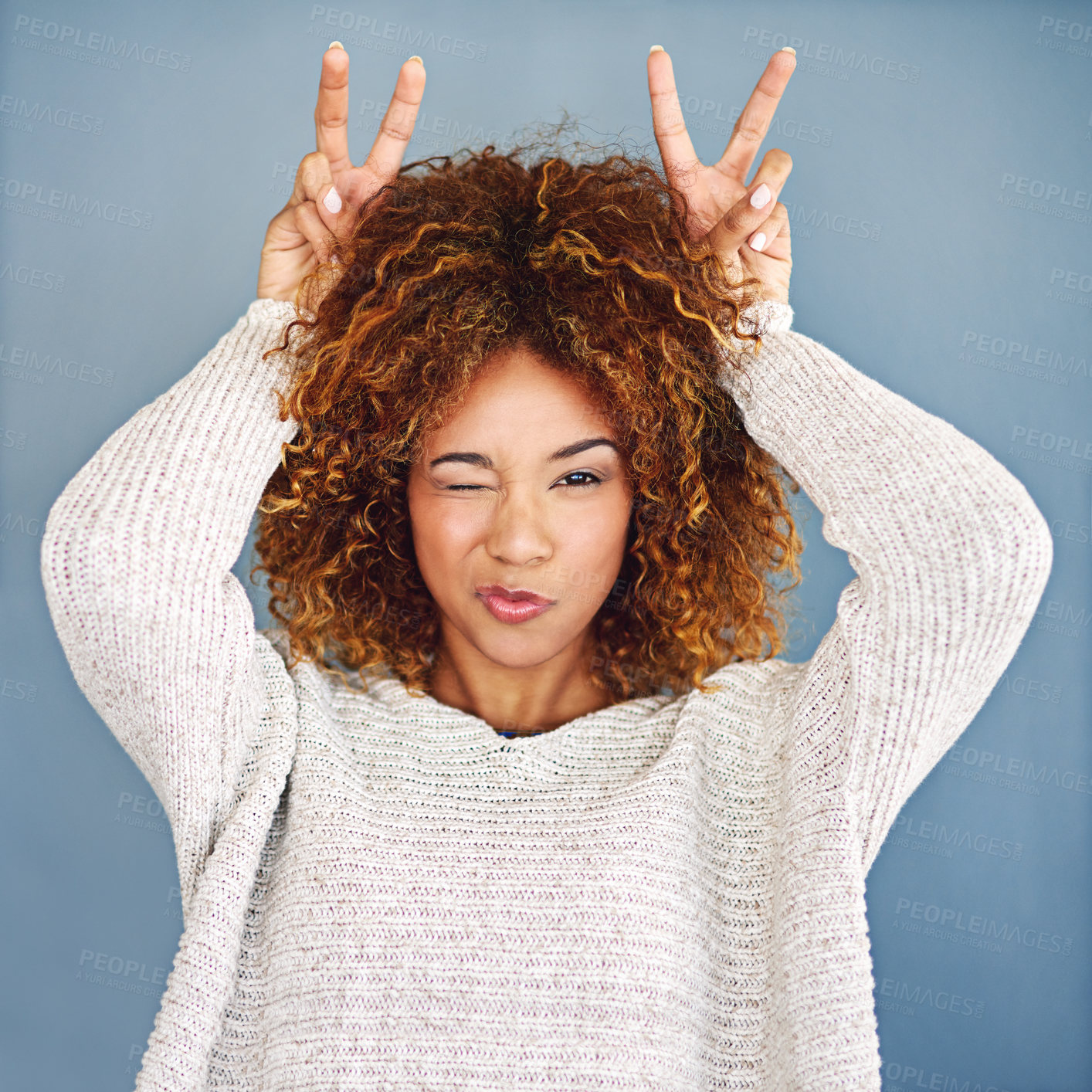 Buy stock photo Studio shot of a young woman making a bunny ear gesture against a grey background