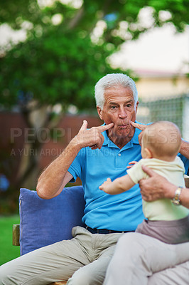 Buy stock photo Shot of a senior man playing with his grandson
