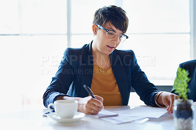 Buy stock photo Shot of a businesswoman working on paperwork in her office
