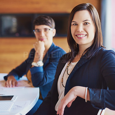 Buy stock photo Cropped portrait of a businesswoman sitting in the boardroom with a colleague in the background