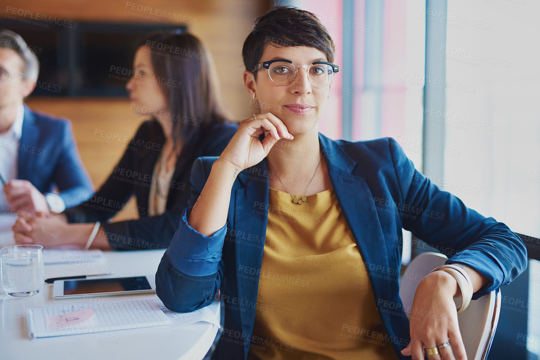 Buy stock photo Cropped portrait of a businesswoman sitting in the boardroom with her colleagues