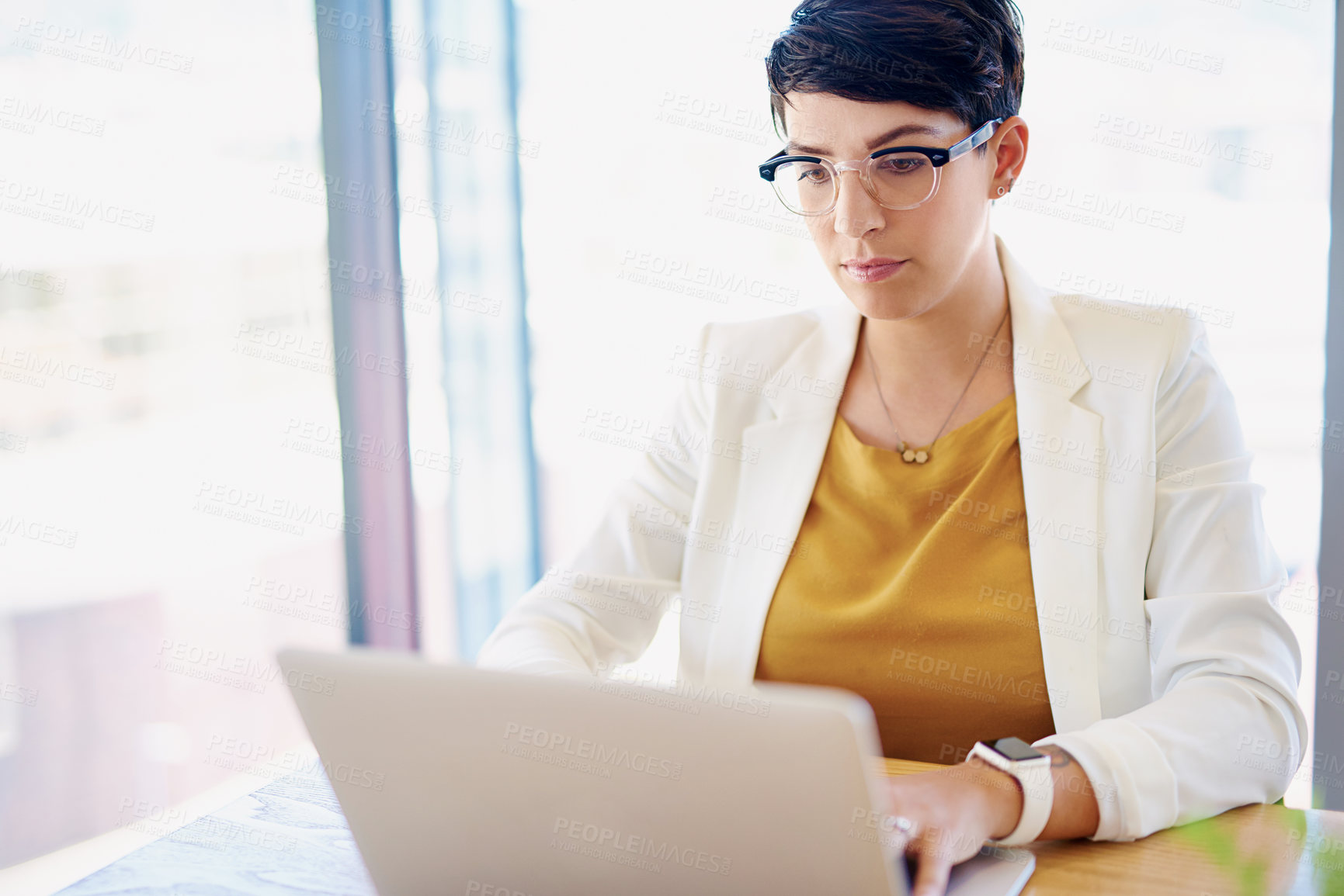 Buy stock photo Shot of a young businesswoman working on a laptop at her desk